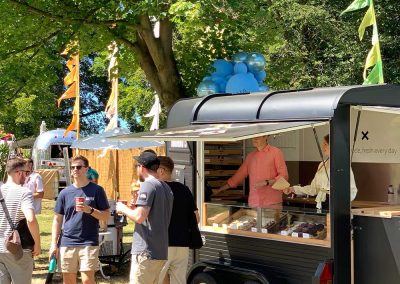 Guys enjoying coffee outside a doughnut and coffee truck